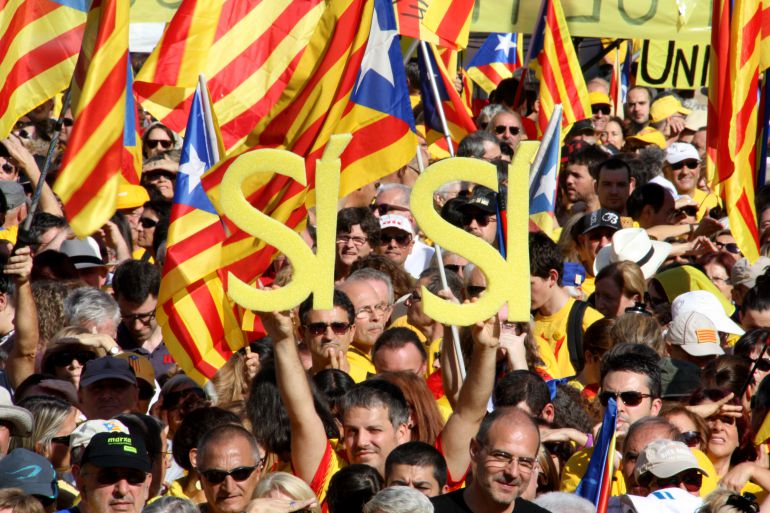 Un noi aguanta un doble sí en al·lusió a la pregunta consensuada per la consulta en una manifestació a Plaça Catalunya Un noi aguanta un doble sí en al·lusió a la pregunta consensuada per la consulta en una manifestació a Plaça Catalunya