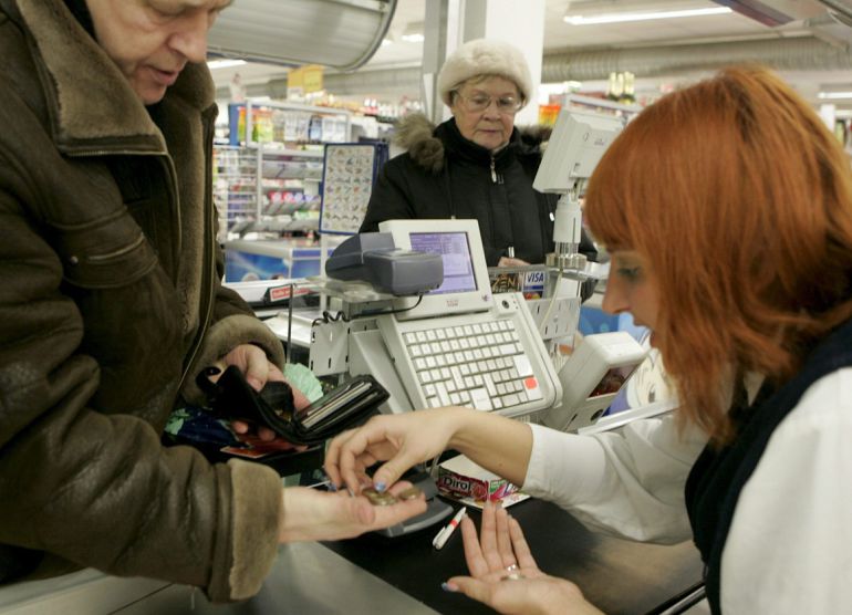 Una cajera ayuda a un cliente a contar las monedas de euro en un supermercado. EFE/Archivo Una cajera ayuda a un cliente a contar las monedas de euro en un supermercado. EFE/Archivo