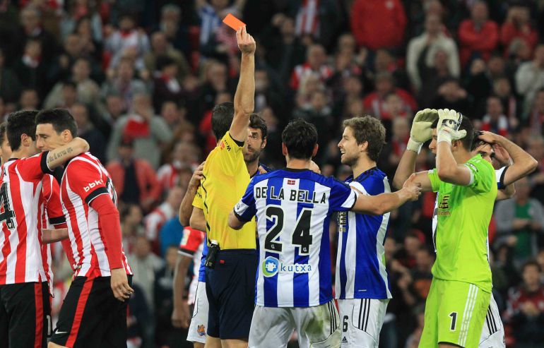 GRA496. BILBAO, 28/04/2015.- El árbitro Martínez Munuera saca tarjeta roja a Mikel González, de la Real Sociedad, durante el encuentro correspondiente a la jornada 34 de Primera División que Athletic Club y Real Sociedad disputan esta noche en el estadio de San Mamés. EFE/Luis Tejido. GRA496. BILBAO, 28/04/2015.- El árbitro Martínez Munuera saca tarjeta roja a Mikel González, de la Real Sociedad, durante el encuentro correspondiente a la jornada 34 de Primera División que Athletic Club y Real Sociedad disputan esta noche en el estadio de San Mamés. EFE/Luis Tejido.