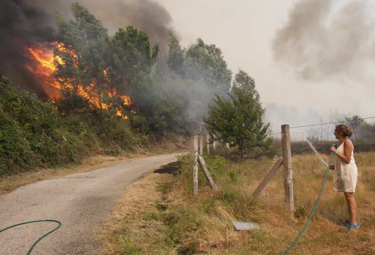 Una mujer observa como llegan a las casas de la zona de Sela las llamas del incendio forestal de Arbo (Pontevedra), en el que se ha decretado la Situación 2, por la cercanía del fuego a núcleos de población. Las hectáreas de monte afectadas por los incendios forestales que se mantienen activos en Galicia son ya cuatro mil, según los últimos datos facilitados por la Xunta. Una mujer observa como llegan a las casas de la zona de Sela las llamas del incendio forestal de Arbo (Pontevedra), en el que se ha decretado la Situación 2, por la cercanía del fuego a núcleos de población. Las hectáreas de monte afectadas por los incendios forestales que se mantienen activos en Galicia son ya cuatro mil, según los últimos datos facilitados por la Xunta.