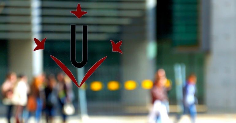 Imatge d'estudiants reflectits en una porta de vidre amb el logotip de la Universitat de Lleida. Imatge d'estudiants reflectits en una porta de vidre amb el logotip de la Universitat de Lleida.