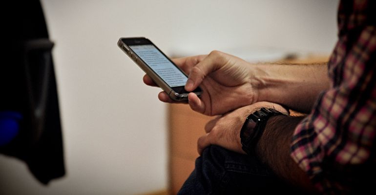 Una persona consulta su teléfono móvil, el medio utilizado para esta estafa. Una persona consulta su teléfono móvil, el medio utilizado para esta estafa.