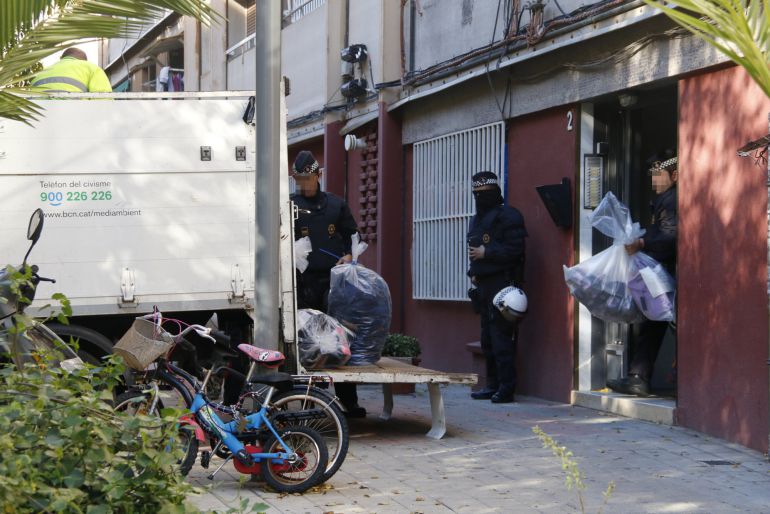 Agents de la Guàrdia Urbana de Barcelona treuen material confiscat en una de les entrades de l'operació contra el top manta Agents de la Guàrdia Urbana de Barcelona treuen material confiscat en una de les entrades de l'operació contra el top manta