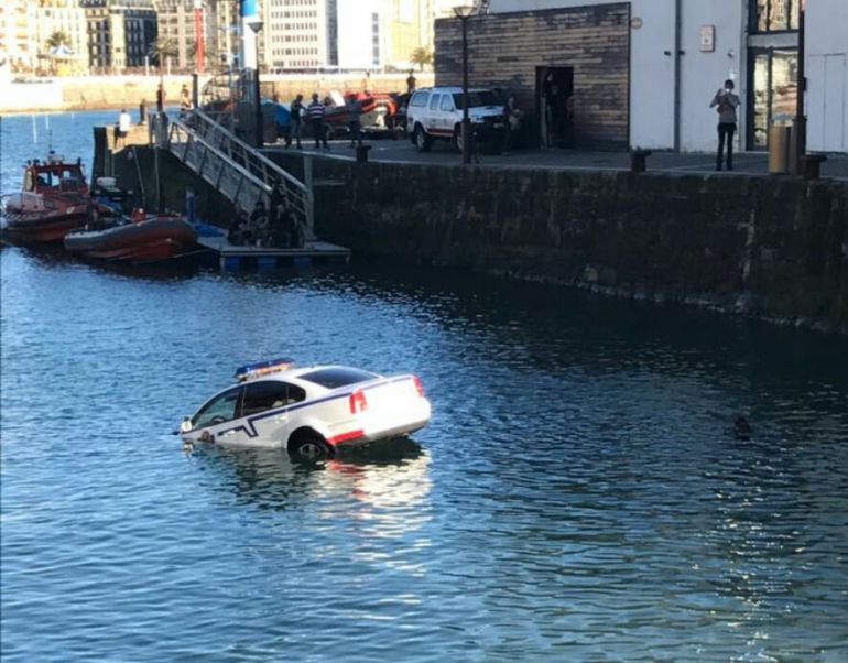 Vista del coche patrulla de la Ertzaintza semi hundido en el puerto donostiarra utilizado para una escena de la serie 'Allí abajo'. Vista del coche patrulla de la Ertzaintza semi hundido en el puerto donostiarra utilizado para una escena de la serie 'Allí abajo'.