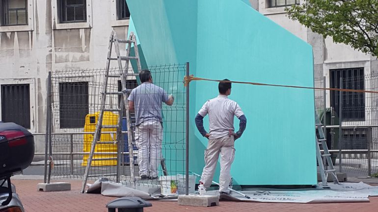Dos operarios ultiman las labores de pintado de la escultura Dos operarios ultiman las labores de pintado de la escultura