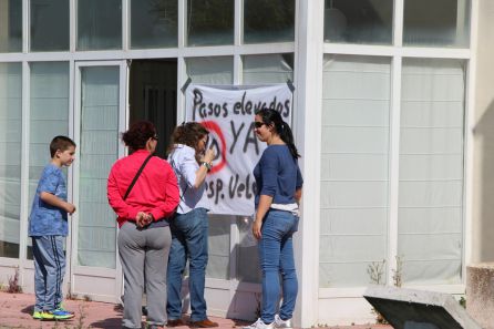 Dos vecinas de Dehesa Mayor colocan la pancarta de reivindicación en las puertas del centro social junto a la SG-205 Dos vecinas de Dehesa Mayor colocan la pancarta de reivindicación en las puertas del centro social junto a la SG-205