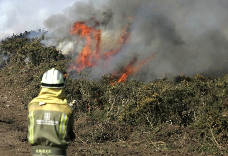 Un bombero trabaja en las labores de extinción de un incendio Un bombero trabaja en las labores de extinción de un incendio