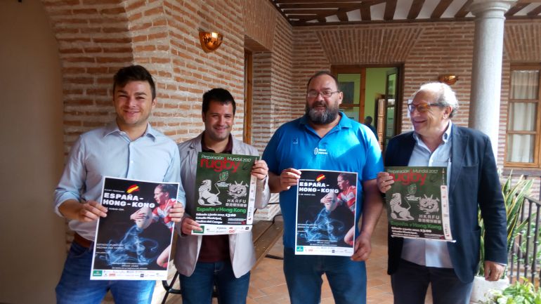 La organización del partido posa con el cartel promocional La organización del partido posa con el cartel promocional