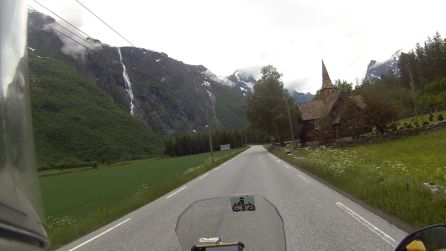 Típica iglesia noruega. El agua de deshielo cae en cascadas por las montañas todavía nevadas Típica iglesia noruega. El agua de deshielo cae en cascadas por las montañas todavía nevadas