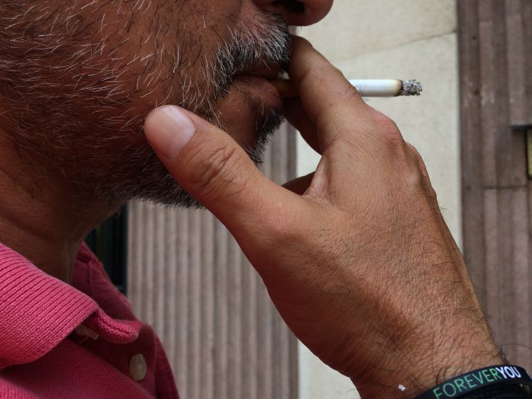 Fumador dando una calada a un cigarrillo Fumador dando una calada a un cigarrillo