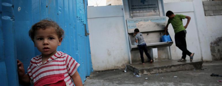 Niños refugiados palestinos llenan contenedores con agua potable de grifos públicos Niños refugiados palestinos llenan contenedores con agua potable de grifos públicos