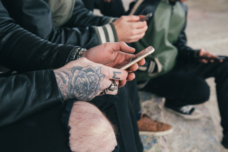 Adolescentes manipulan sus teléfonos móviles Adolescentes manipulan sus teléfonos móviles