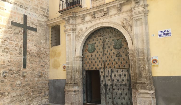 La inscripción y los escudos se encuentran junto a la cruz, a la entrada del Palacio Episcopal La inscripción y los escudos se encuentran junto a la cruz, a la entrada del Palacio Episcopal