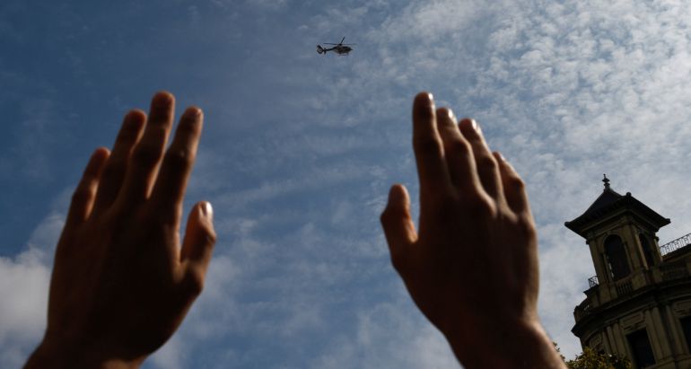 A man holds up his hands as a police helicopter flies overhead during a protest a day after the banned independence referendum in Barcelona, Spain October 2, 2017 A man holds up his hands as a police helicopter flies overhead during a protest a day after the banned independence referendum in Barcelona, Spain October 2, 2017