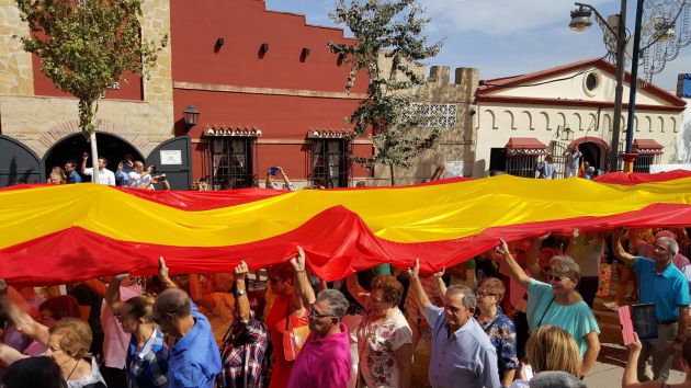 Los vecinos y muchos visitantes han participado en el acto para desplegar la bandera española Los vecinos y muchos visitantes han participado en el acto para desplegar la bandera española