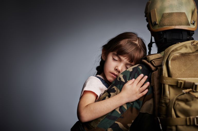 Niña durmiendo en brazos de un militar