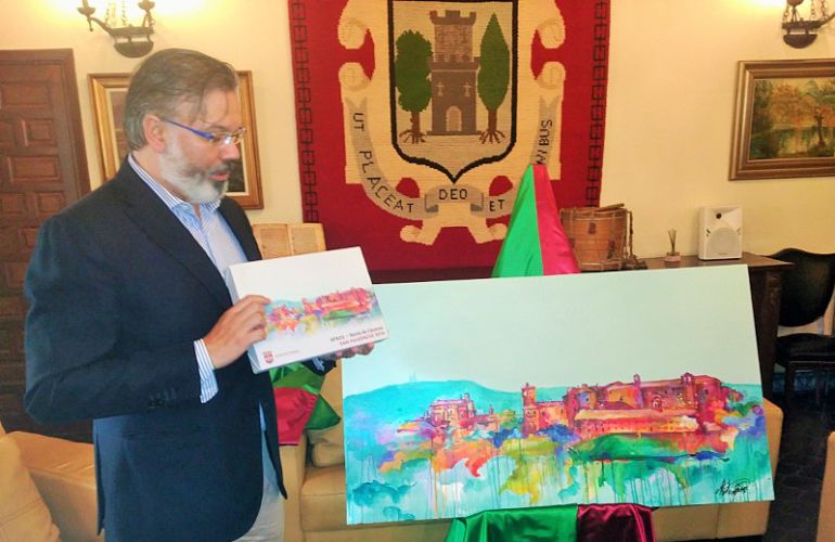 Fernando Pizarro, sostiene el lienzo que se entregará a los ganadores del premio San Fulgencio ante la obra original Fernando Pizarro, sostiene el lienzo que se entregará a los ganadores del premio San Fulgencio ante la obra original