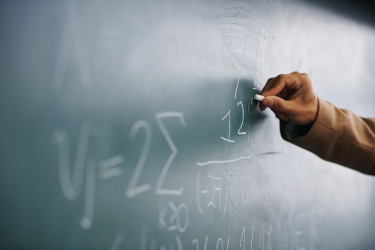 Un profesor universitario escribe en la pizarra Un profesor universitario escribe en la pizarra