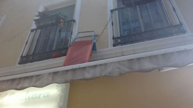 Turistas que han dejado colgadas sillas de playa en las fachadas de los edificios Turistas que han dejado colgadas sillas de playa en las fachadas de los edificios