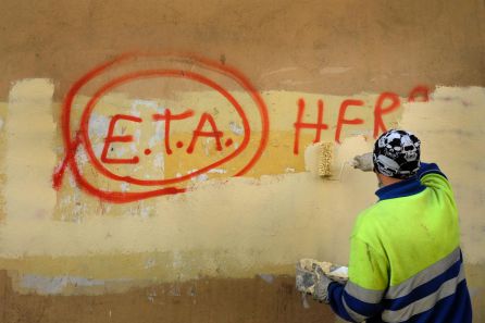 Un trabajador municipal pinta sobre el graffiti leyendo "ETA, El pueblo está contigo" en Gernika, un día después de que el grupo separatista vasco ETA anunciara un cese definitivo de la actividad armada.
