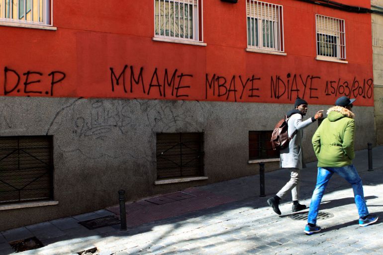 Dos personas pasan delante de una pintada en el madrileño barrio de Lavapiés, en memoria del "mantero" senegalés de 35 años que el jueves murió tras sufrir una parada cardiorrespiratoria Dos personas pasan delante de una pintada en el madrileño barrio de Lavapiés, en memoria del "mantero" senegalés de 35 años que el jueves murió tras sufrir una parada cardiorrespiratoria