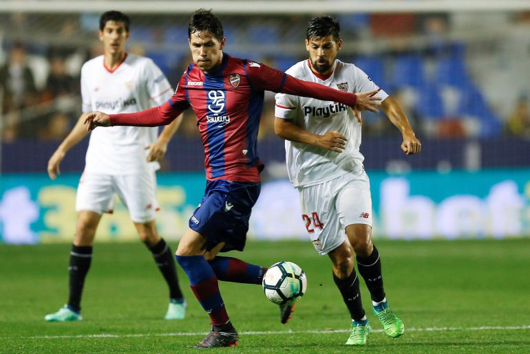 El centrocampista serbio del Levante Sasa Lukic (c) juega un balón ante Nolito, del Sevilla, durante el partido de Liga en Primera División que están disputando esta noche en el estadio Ciutat de Valencia. El centrocampista serbio del Levante Sasa Lukic (c) juega un balón ante Nolito, del Sevilla, durante el partido de Liga en Primera División que están disputando esta noche en el estadio Ciutat de Valencia.
