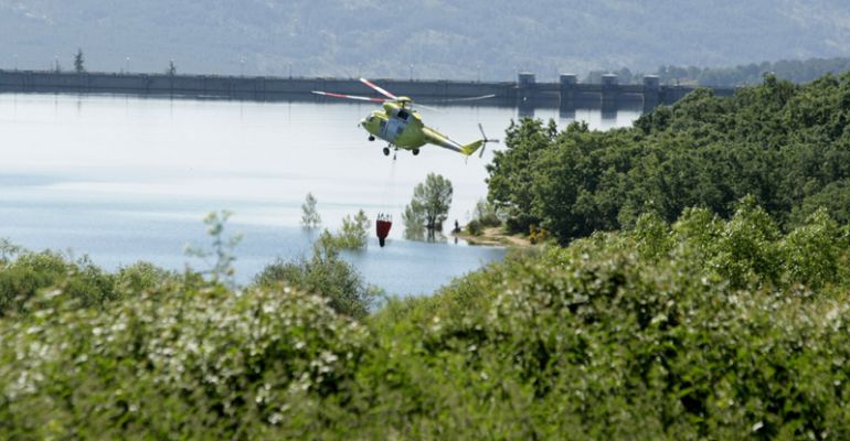 Helicóptero recogiendo agua durante la extinción de un incendio Helicóptero recogiendo agua durante la extinción de un incendio