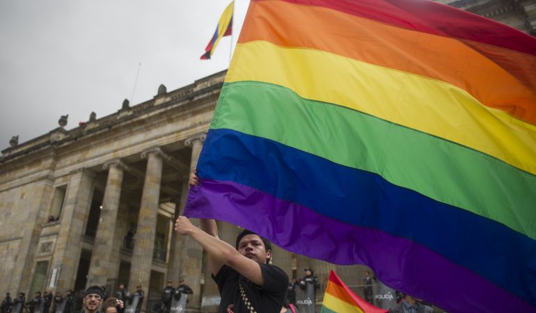 Un joven ondea una bandera LGTBI Un joven ondea una bandera LGTBI