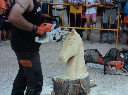 Un motoserrista talla la cabeza de un caballo en el festival de la Sierra y el Hombre Un motoserrista talla la cabeza de un caballo en el festival de la Sierra y el Hombre