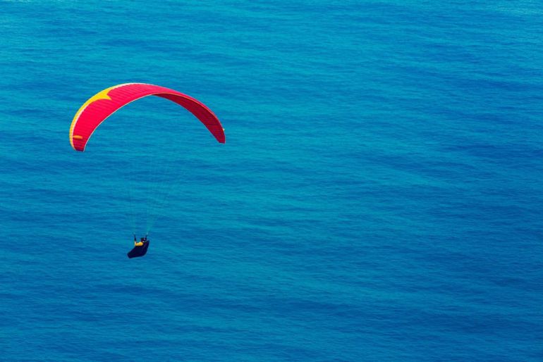 Una persona practica parapente. Una persona practica parapente.
