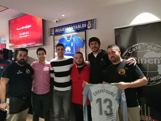 Nereo Champagne posa con una camiseta del Real Oviedo junto al resto de tertulianos y trabajadores de la Cafetería Continental. Nereo Champagne posa con una camiseta del Real Oviedo junto al resto de tertulianos y trabajadores de la Cafetería Continental.