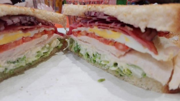 El sándwich de pollo completo, partido en dos mitades El sándwich de pollo completo, partido en dos mitades