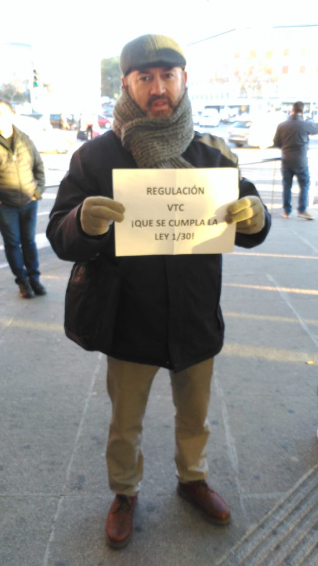 Un taxista muestra un cartel en el que exige que se cumpla la ley. Un taxista muestra un cartel en el que exige que se cumpla la ley.