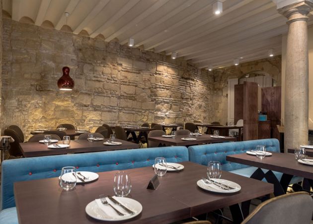 Comedor con varias confituraciones de mesas y piedra de las antiguas caballerizas Comedor con varias confituraciones de mesas y piedra de las antiguas caballerizas