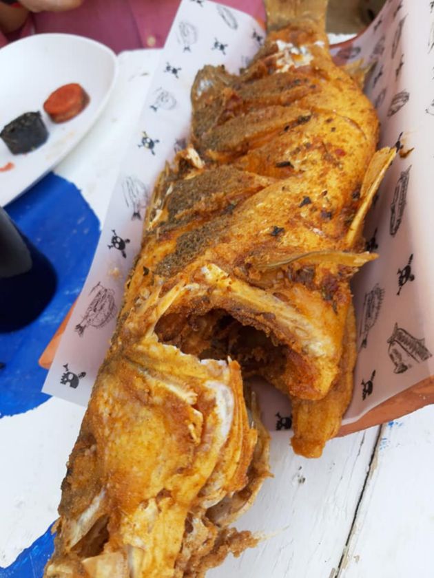 Deliciosa lubina frita servida en una teja Deliciosa lubina frita servida en una teja