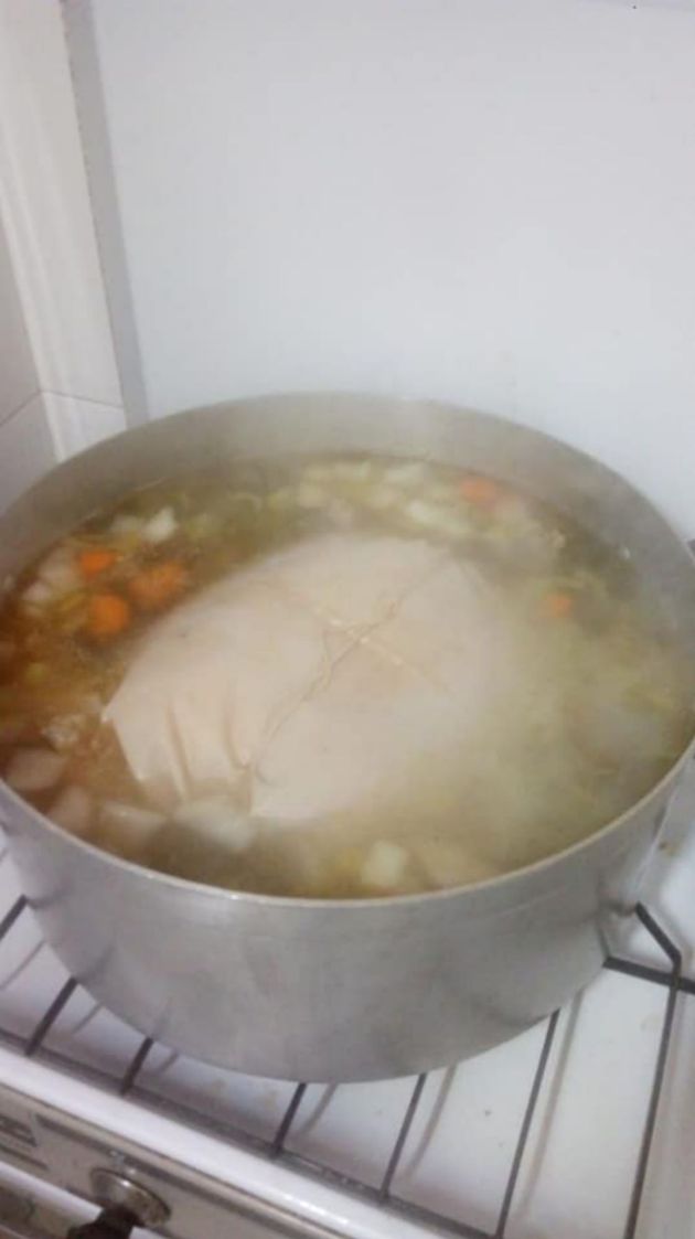 El pavo trufado, cociéndose en la olla con el consomé El pavo trufado, cociéndose en la olla con el consomé