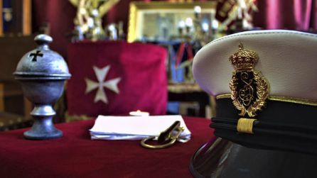 Gorra blanca y tintes negros a juego con todo el conjunto con algunos detalles metálicos con baño de oro, con las siglas ‘S.J.’ entrelazadas rodeada de Laurel como símbolo de triunfo y fuerza, de nuevo con la corona real Gorra blanca y tintes negros a juego con todo el conjunto con algunos detalles metálicos con baño de oro, con las siglas ‘S.J.’ entrelazadas rodeada de Laurel como símbolo de triunfo y fuerza, de nuevo con la corona real