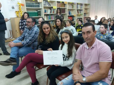 Zaira, entre sus padres, muestra el diploma acreditativo Zaira, entre sus padres, muestra el diploma acreditativo