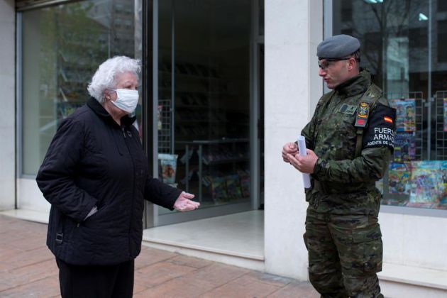 Miembro del Ejercito de Tierra en la calle junto a una vecina Miembro del Ejercito de Tierra en la calle junto a una vecina