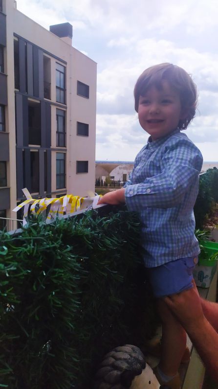 Niño con una palma elaborada de manualidades Niño con una palma elaborada de manualidades