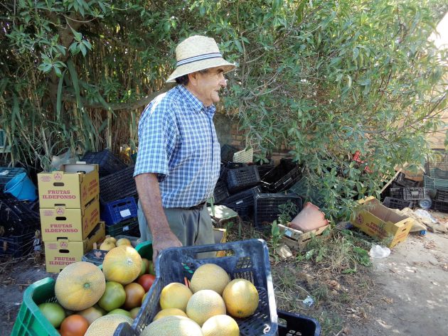 Juan, rodeado de cajas con frutas y verduras de su fértil huerta Juan, rodeado de cajas con frutas y verduras de su fértil huerta