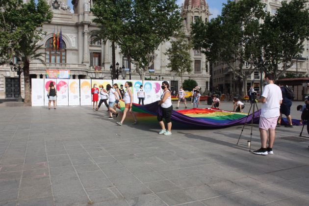 Miembros de Lambda extendiendo la bandera arcoíris en la Plaza del Ayuntamiento de València en el día del Orgullo 2020 Miembros de Lambda extendiendo la bandera arcoíris en la Plaza del Ayuntamiento de València en el día del Orgullo 2020