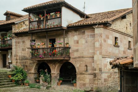 Casona de piedra labrada con sus balcones floridos Casona de piedra labrada con sus balcones floridos