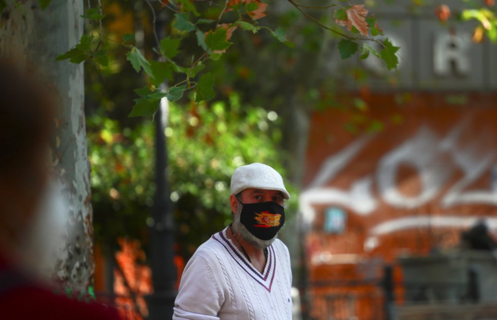 Un vecino pasea por el barrio confinado de Vallecas. Un vecino pasea por el barrio confinado de Vallecas.
