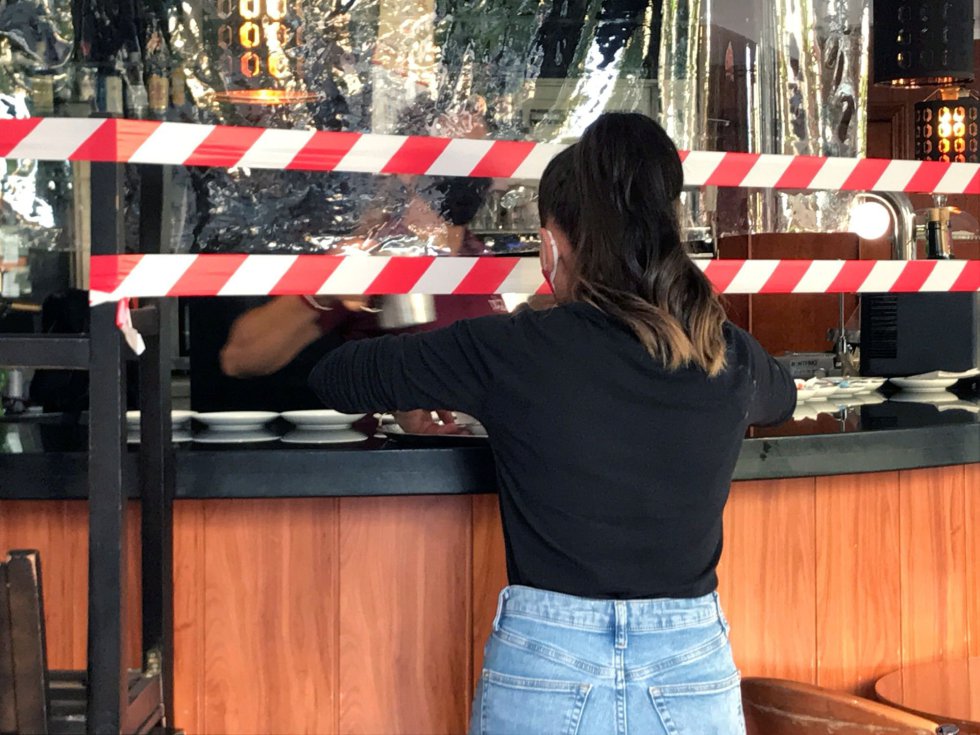 Una camarera se prepara para llevar el pedido a una mesa delante de las cintas que advierten de que la barra de la cafetería del hostal Don Pedro, al lado de hospital Gomez Ulla, en el barrio de Vista Alegre, ha sido clausurada este lunes como medida de prevención contra el coronavirus. Una camarera se prepara para llevar el pedido a una mesa delante de las cintas que advierten de que la barra de la cafetería del hostal Don Pedro, al lado de hospital Gomez Ulla, en el barrio de Vista Alegre, ha sido clausurada este lunes como medida de prevención contra el coronavirus.