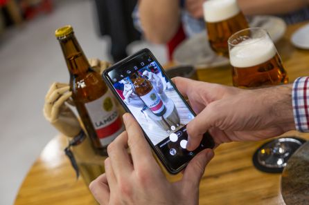 Un comensal toma una fotografía del botellín de 33 cl con su smartphone Un comensal toma una fotografía del botellín de 33 cl con su smartphone