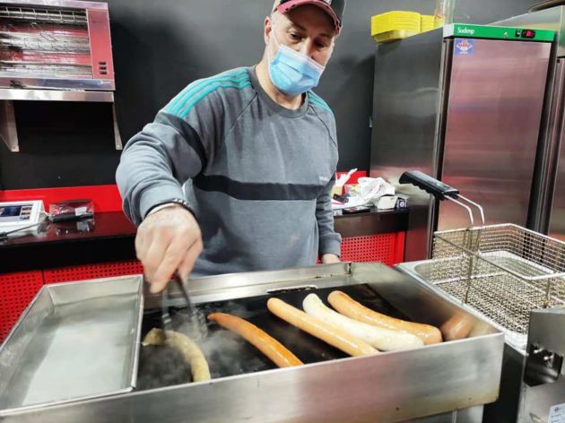 Kiko Rodríguez, delante de la plancha y el recipiente donde previamente cuece las salchichas Kiko Rodríguez, delante de la plancha y el recipiente donde previamente cuece las salchichas