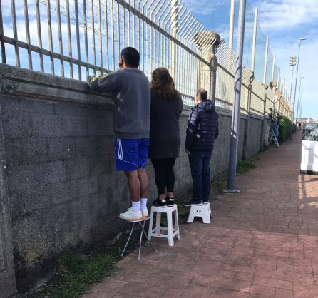 Gente viendo el partido desde el exterior de los campos Gente viendo el partido desde el exterior de los campos
