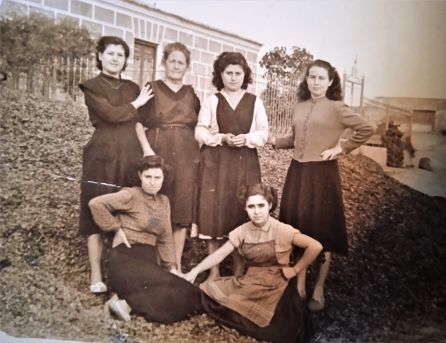 Izquierda a derecha arriba: Amparo Conesa, su madre Amparo Pagán y su hermana María Conesa, junto a otras mujeres encima de un enorme montón de cascaras de almendras, en la puerta del almacén de Pencho "El Santero", en la población de San Isidro. Década de los años 50, Izquierda a derecha arriba: Amparo Conesa, su madre Amparo Pagán y su hermana María Conesa, junto a otras mujeres encima de un enorme montón de cascaras de almendras, en la puerta del almacén de Pencho "El Santero", en la población de San Isidro. Década de los años 50,