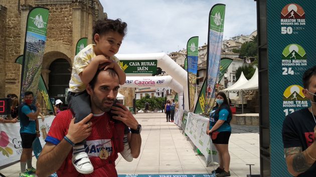 Un niño cruza la linea de meta con su padre Un niño cruza la linea de meta con su padre